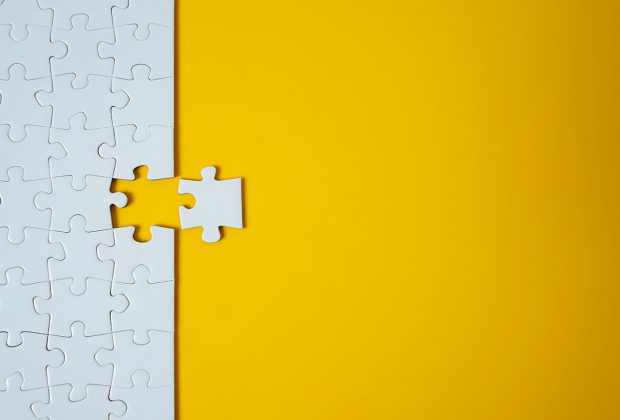 a Jigsaw on yellow background with one piece removed